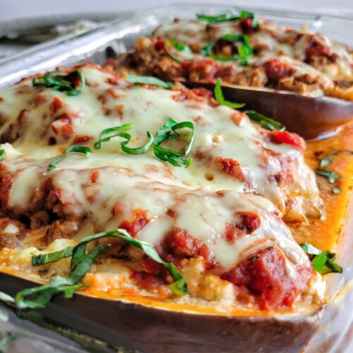lasagna stuffed eggplant in a baking dish topped with fresh chopped basil