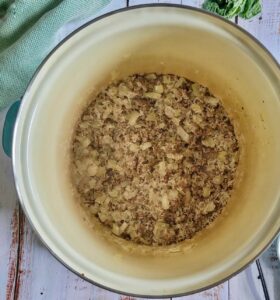 cooked ground beef, diced white onions and rice in a pot