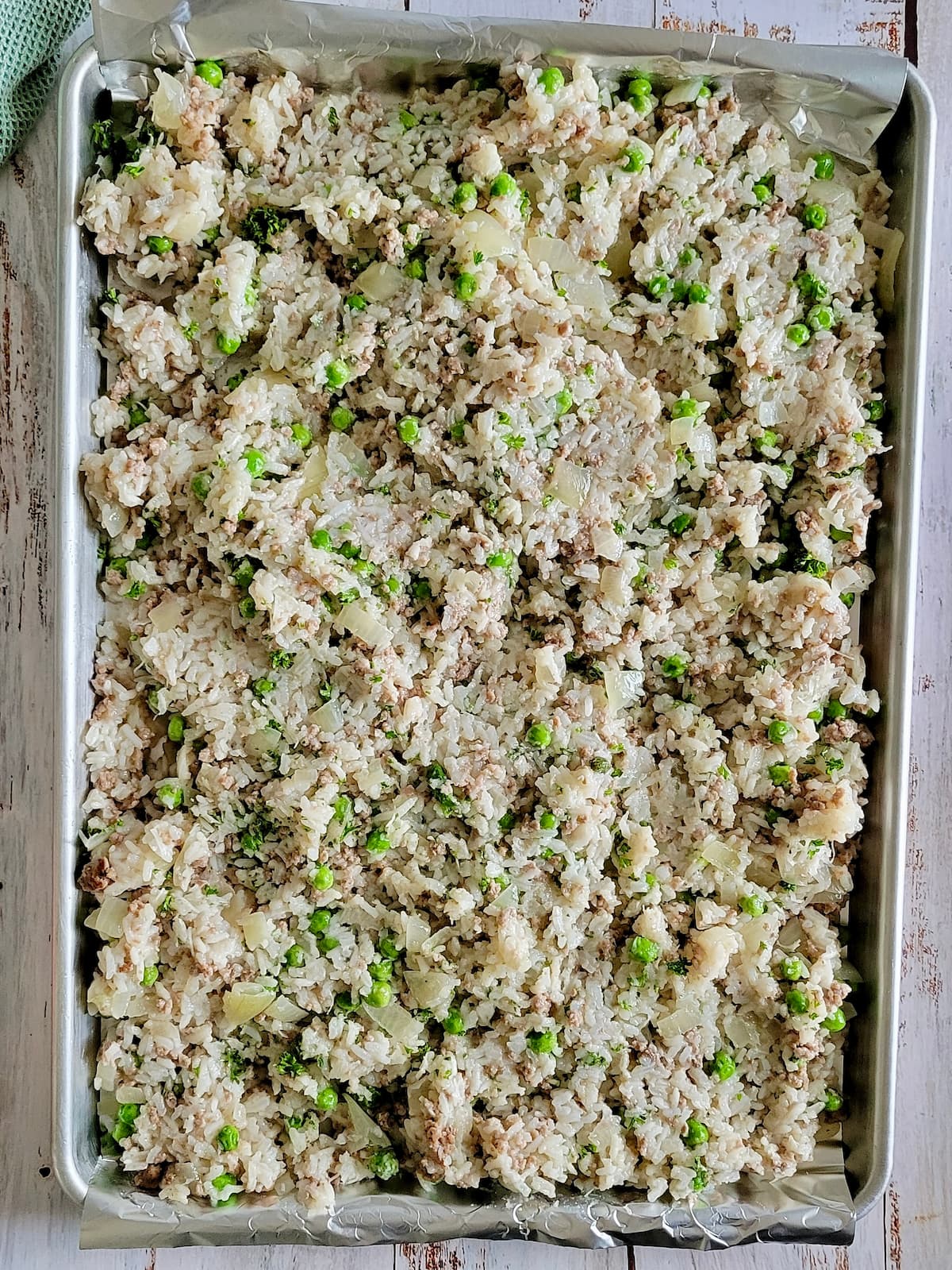 sheet pan of cooked rice, peas, onions and ground beef