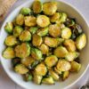 bowl of crispy brussels sprouts garnished with flakey sea salt