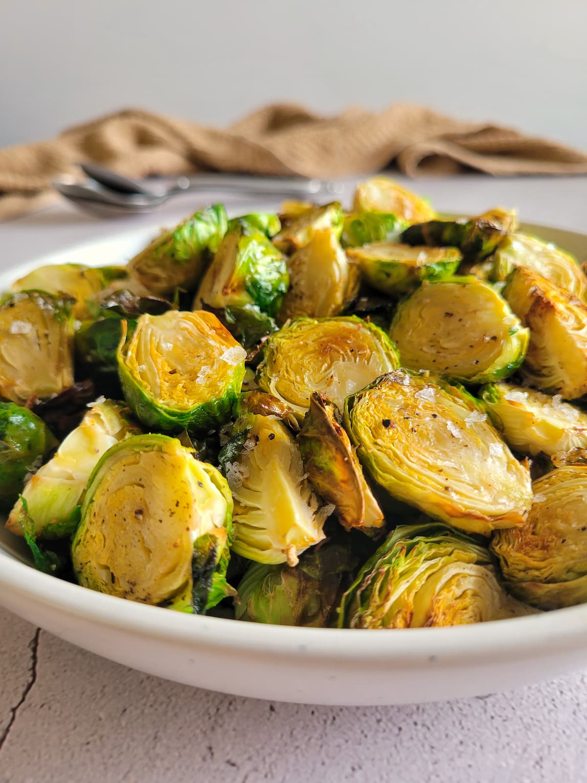 air fried brussels sprouts piled into a bowl garnished with maldon flakey sea salt