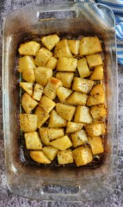 cooked seasoned potato chunks in a casserole dish