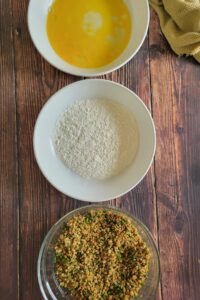 3 bowls - one of beaten egg, one of flour and one of a quinoa coating mixture