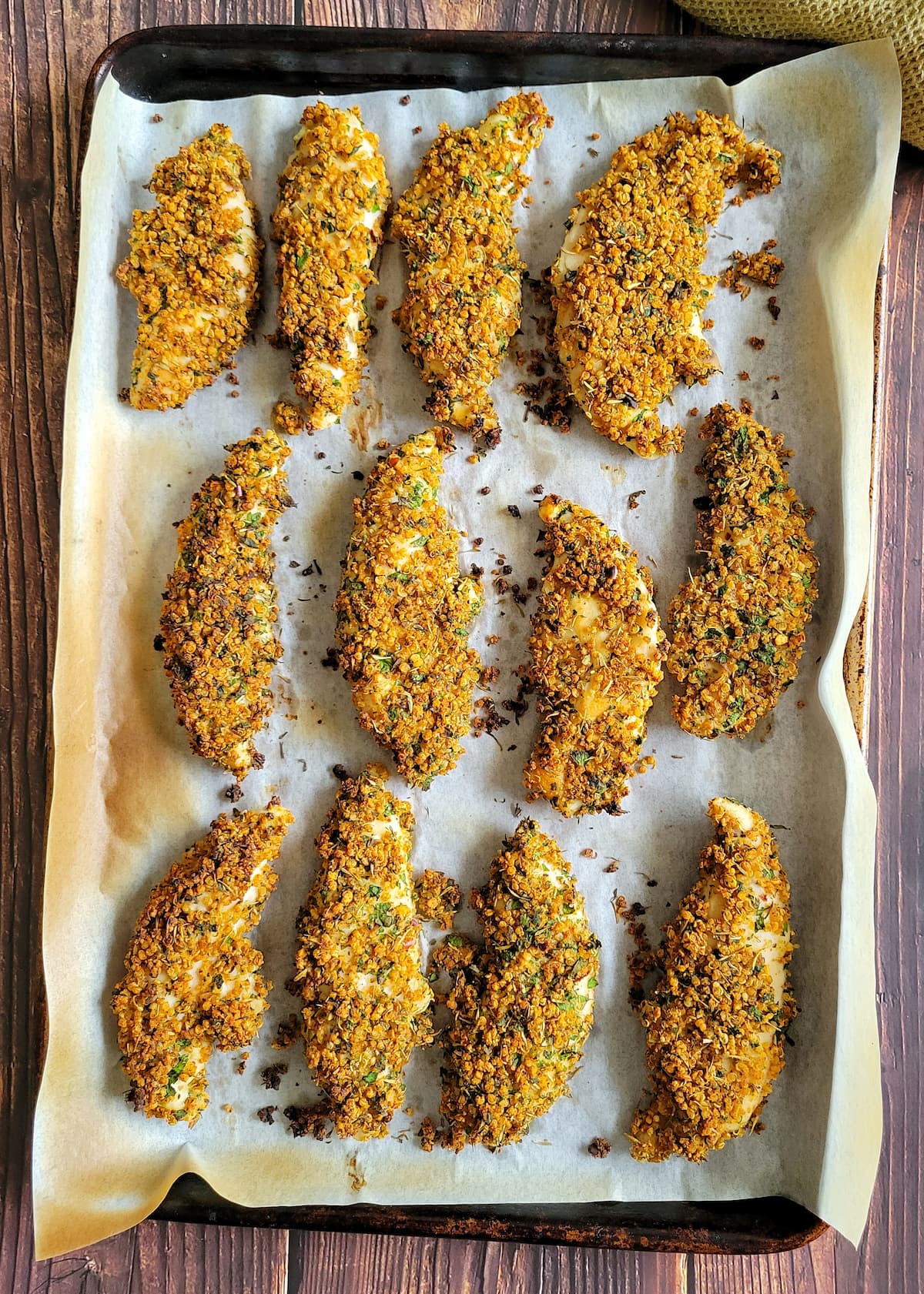 crispy chicken tenders on a parchment lined baking sheet
