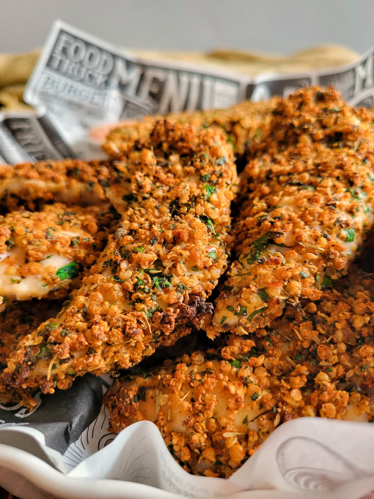 quinoa coated chicken tenders in a lined basket