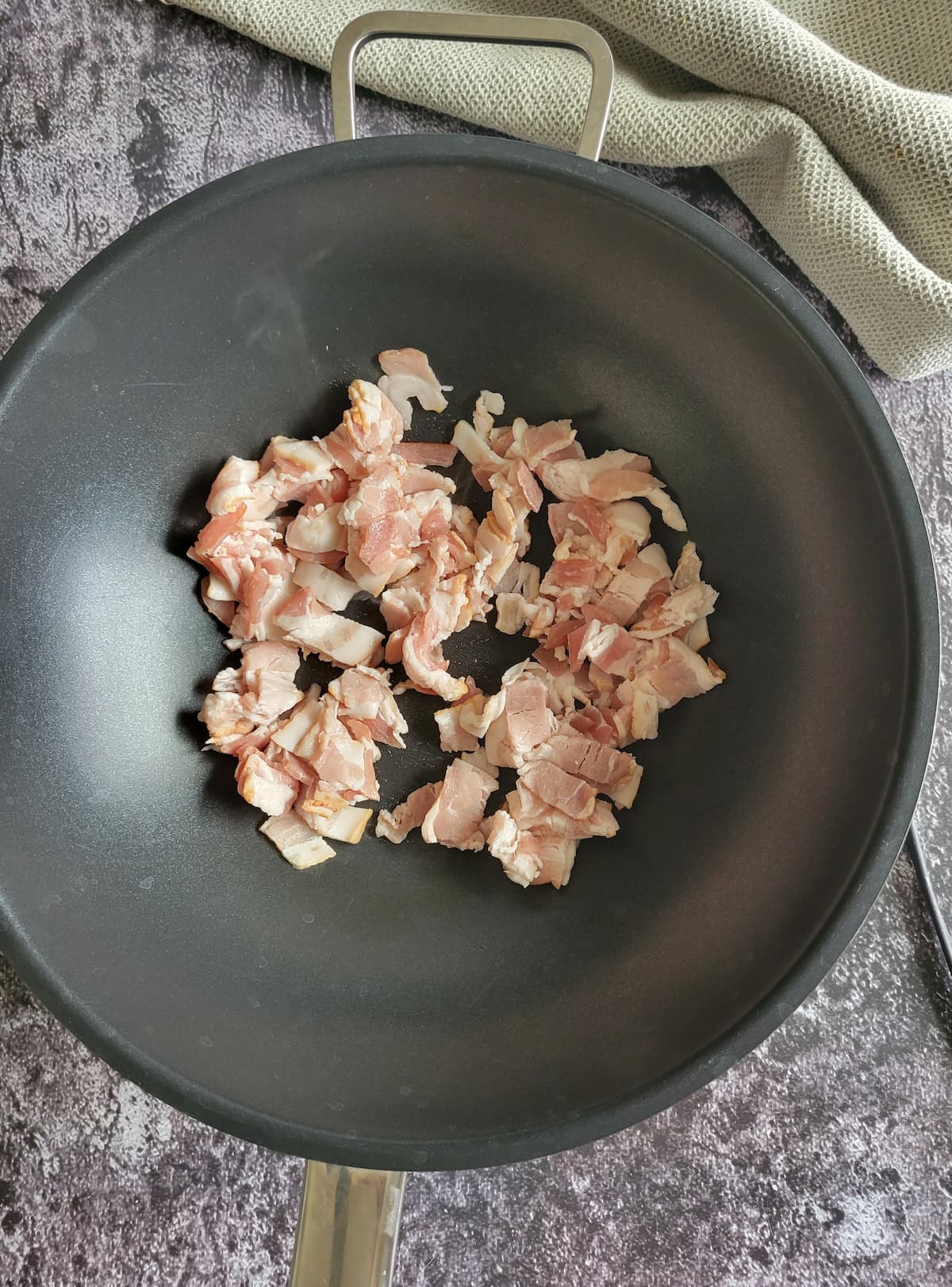 raw diced bacon in a wok