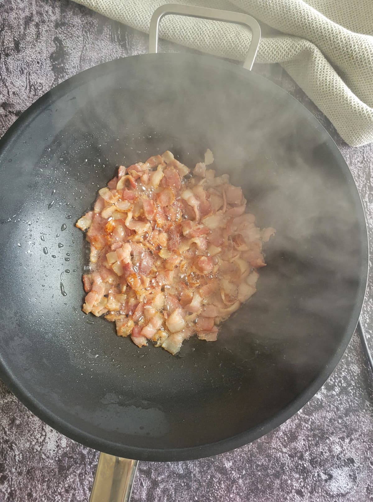 diced bacon cooking in a wok