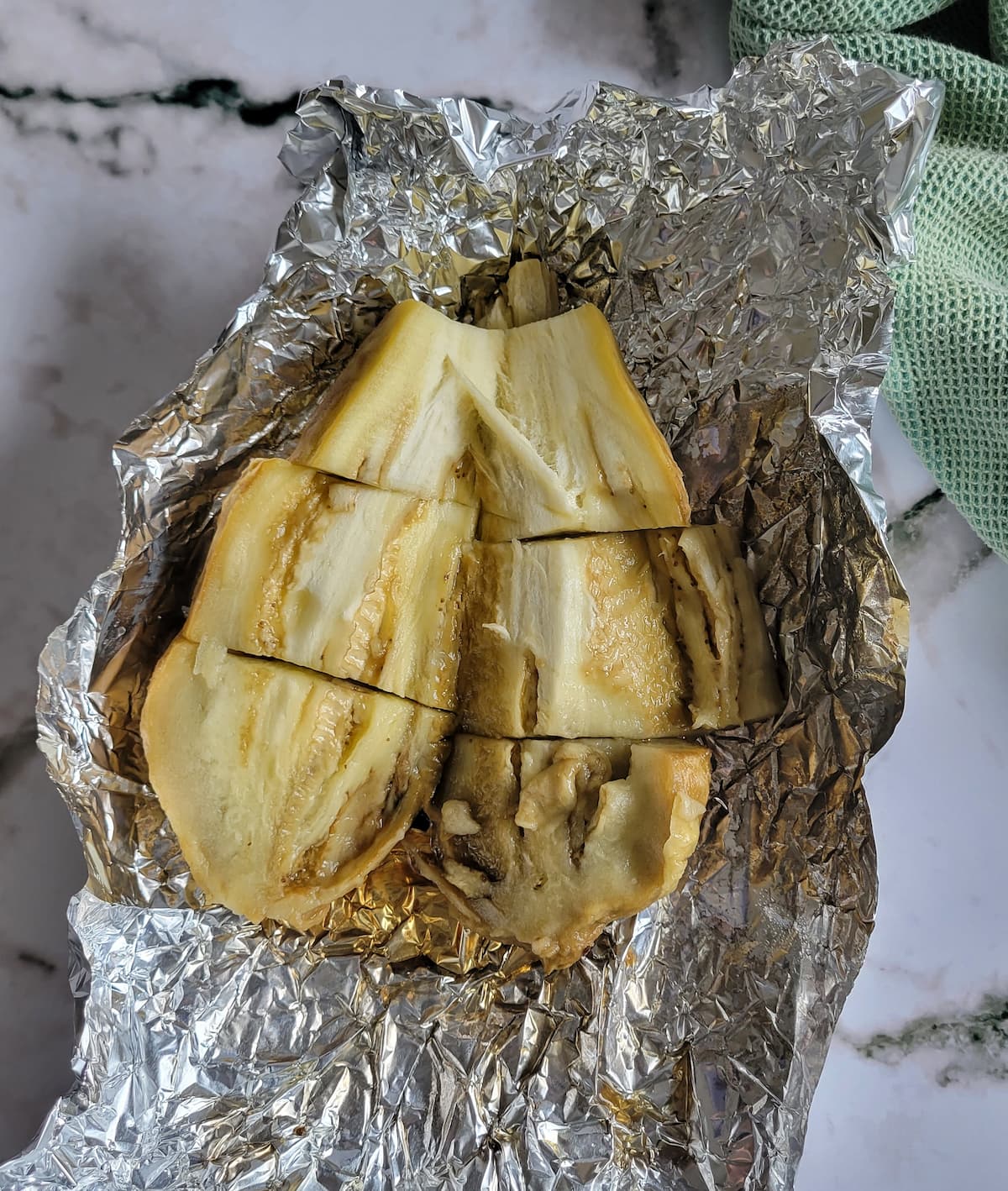 whole roasted eggplant in foil sliced in half and then into thirds
