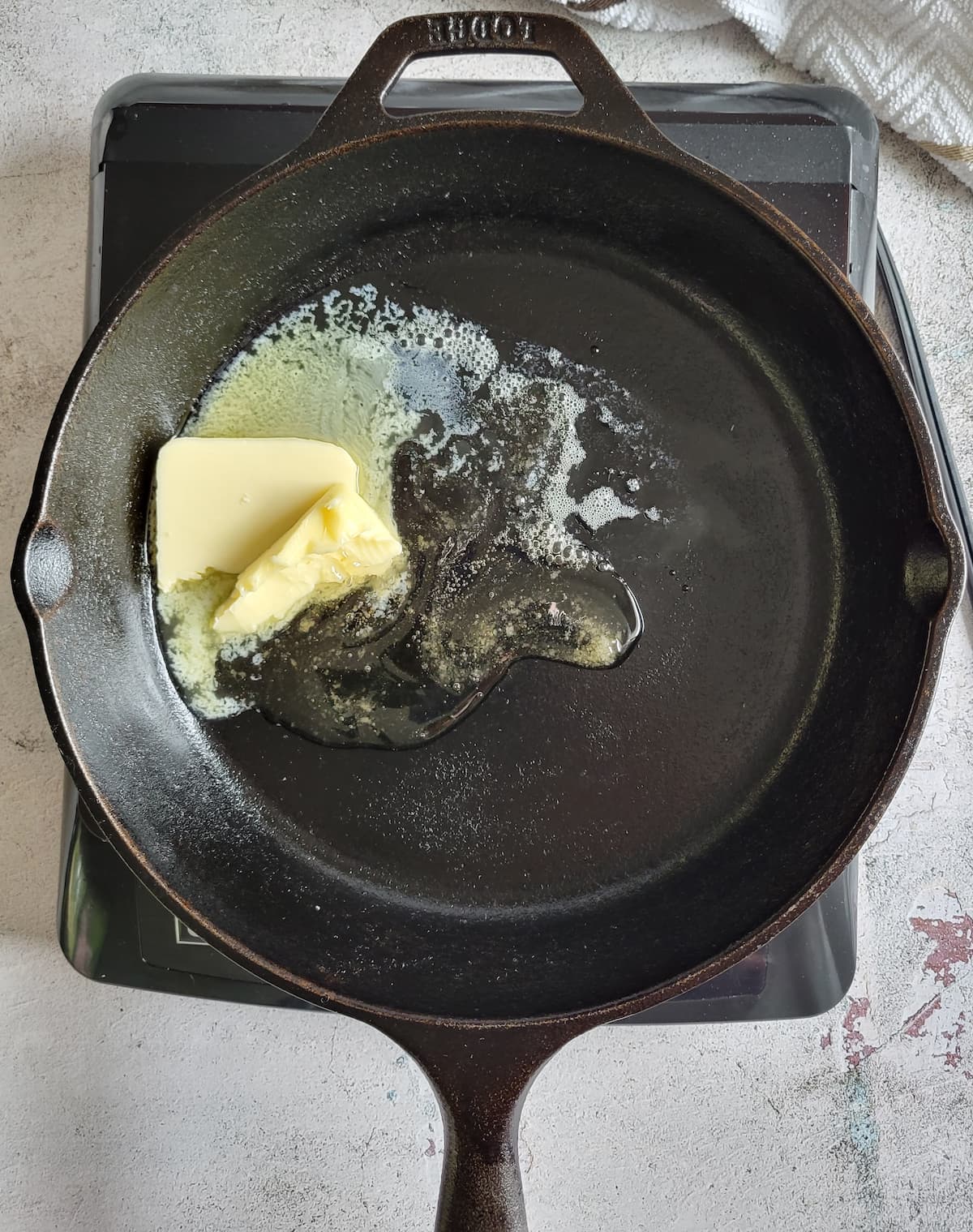 honey and butter melting in a cast iron skillet on a burner