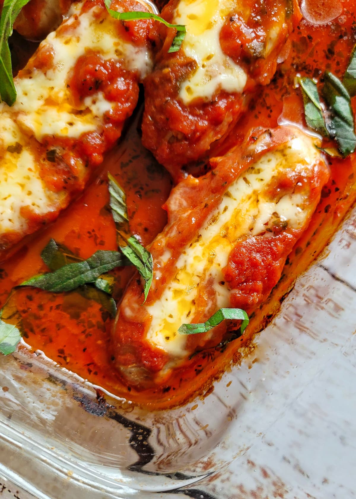 melted cheese stuffed sausages in tomato sauce with fresh basil