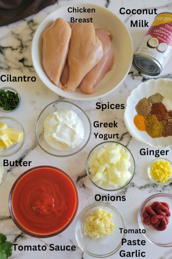 ingredients for recipe for butter chicken - chicken breasts, coconut milk, spices, greek yogurt, ginger, garlic, onions, tomato sauce, tomato paste, butter, cilantro