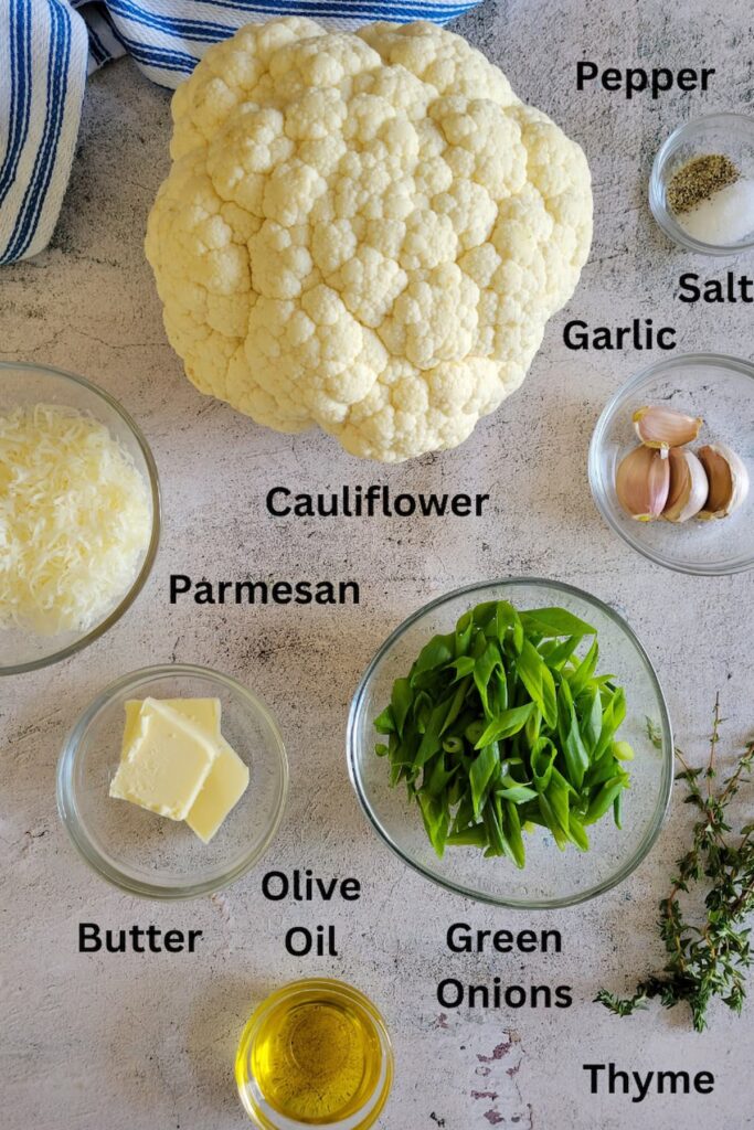 ingredients for cauliflower as mashed potatoes - cauliflower, olive oil, parmesan, green onions, garlic, salt, pepper, thyme, butter