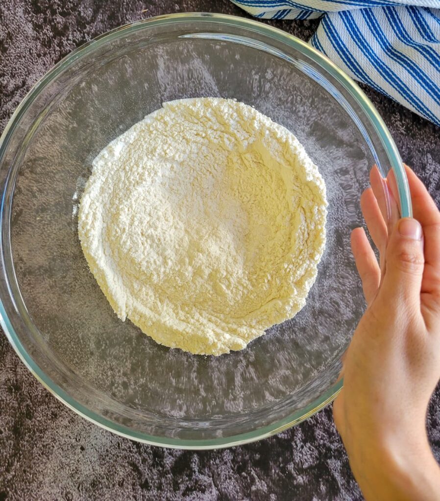 hand holding a bowl of flour