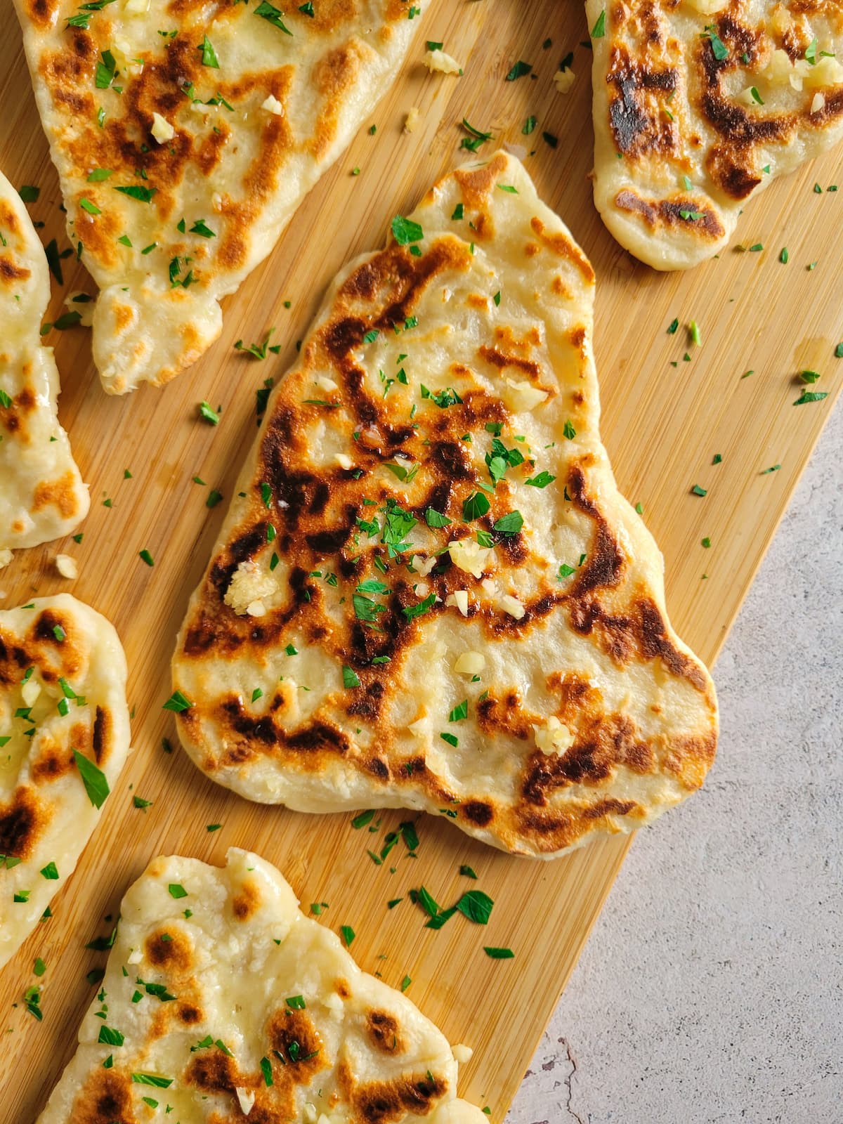 pieces of garlic naan bread on a cutting board