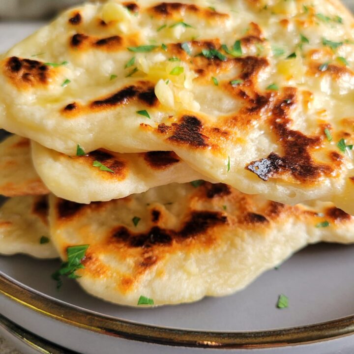 garlic naan bread piled on double plates