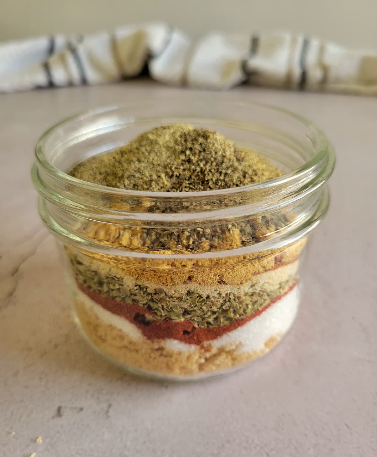 several spices layered in a small jar