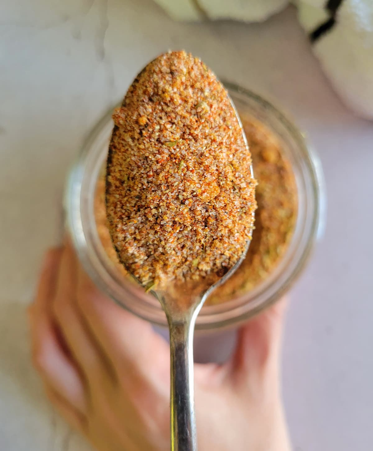spoonful of blended spices over a jar of the rest