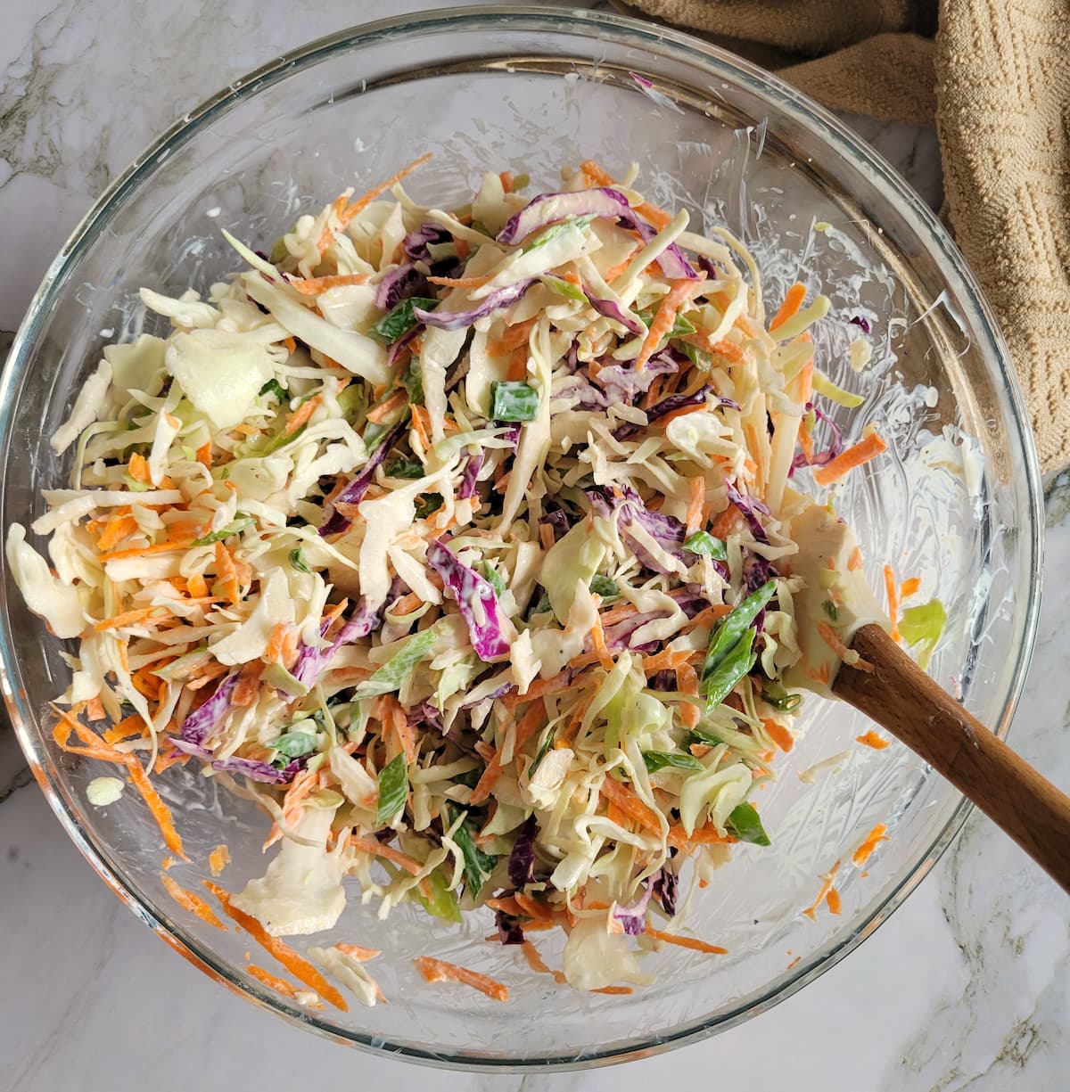 creamy coleslaw mixed in a bowl, rubber spatula in the bowl