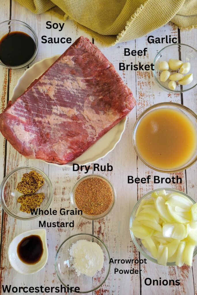 ingredients for beef brisket in the slow cooker - beef brisket, beef broth, onions, garlic, arrowroot powder, dry rub, whole grain mustard, soy sauce, worcestershire sauce
