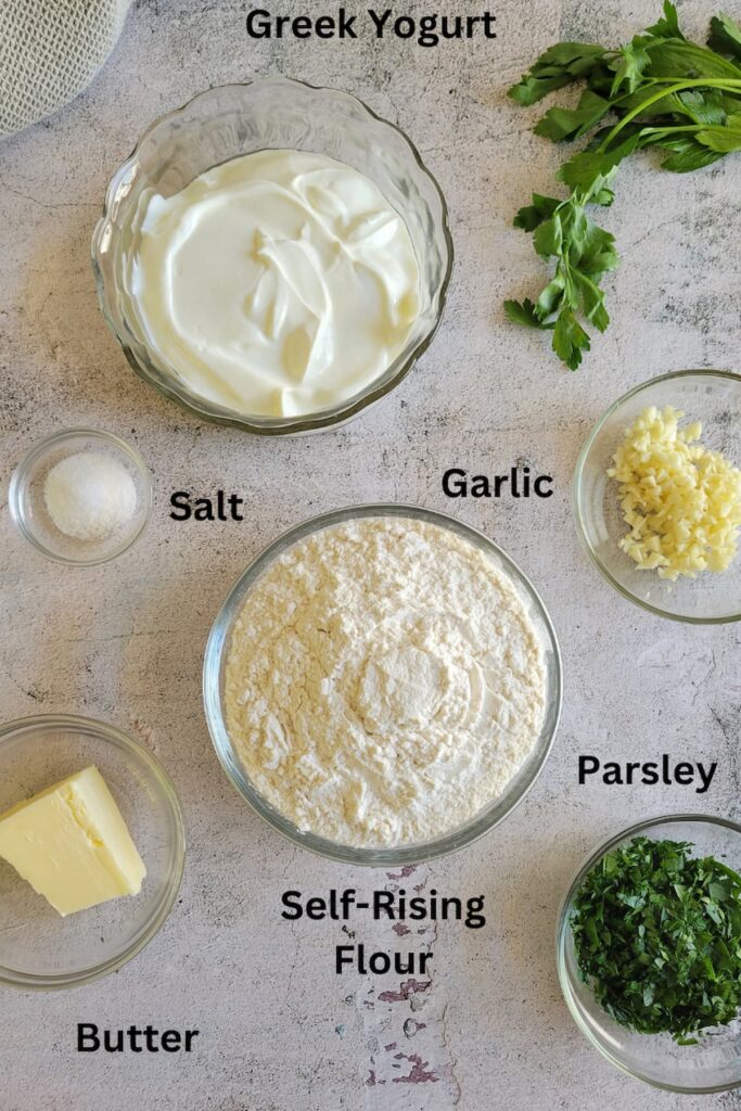 ingredients for simple recipe for naan bread - greek yogurt, self-rising flour, salt, garlic, butter, parsley