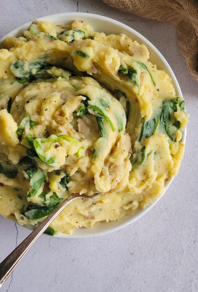 spinach mashed potatoes in a bowl with a spoon