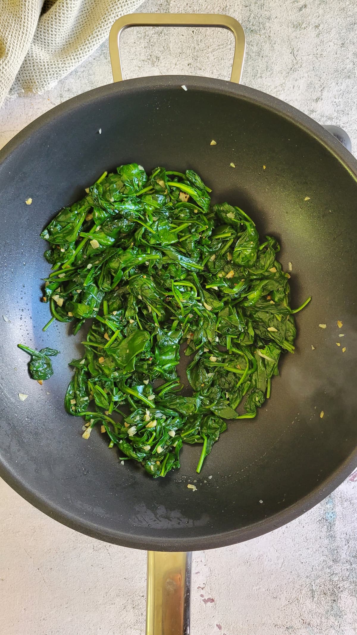 minced garlic and sauteed spinach in a wok