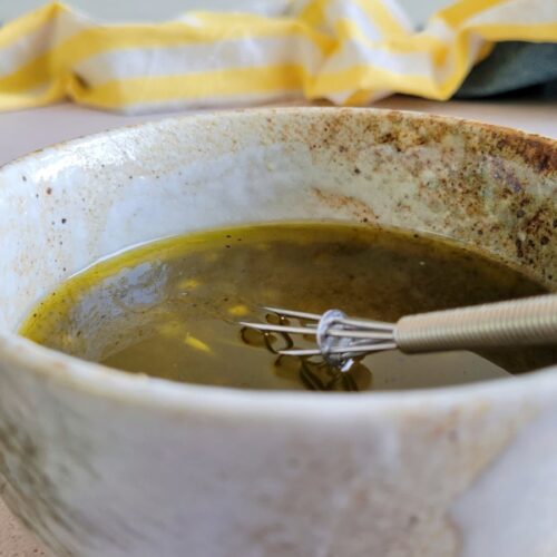 poppy seed dressing in a bowl with a whisk