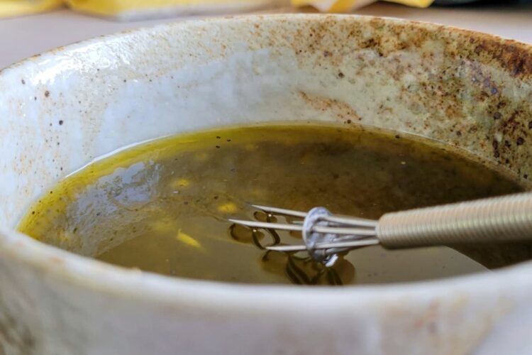 poppy seed dressing in a bowl with a whisk
