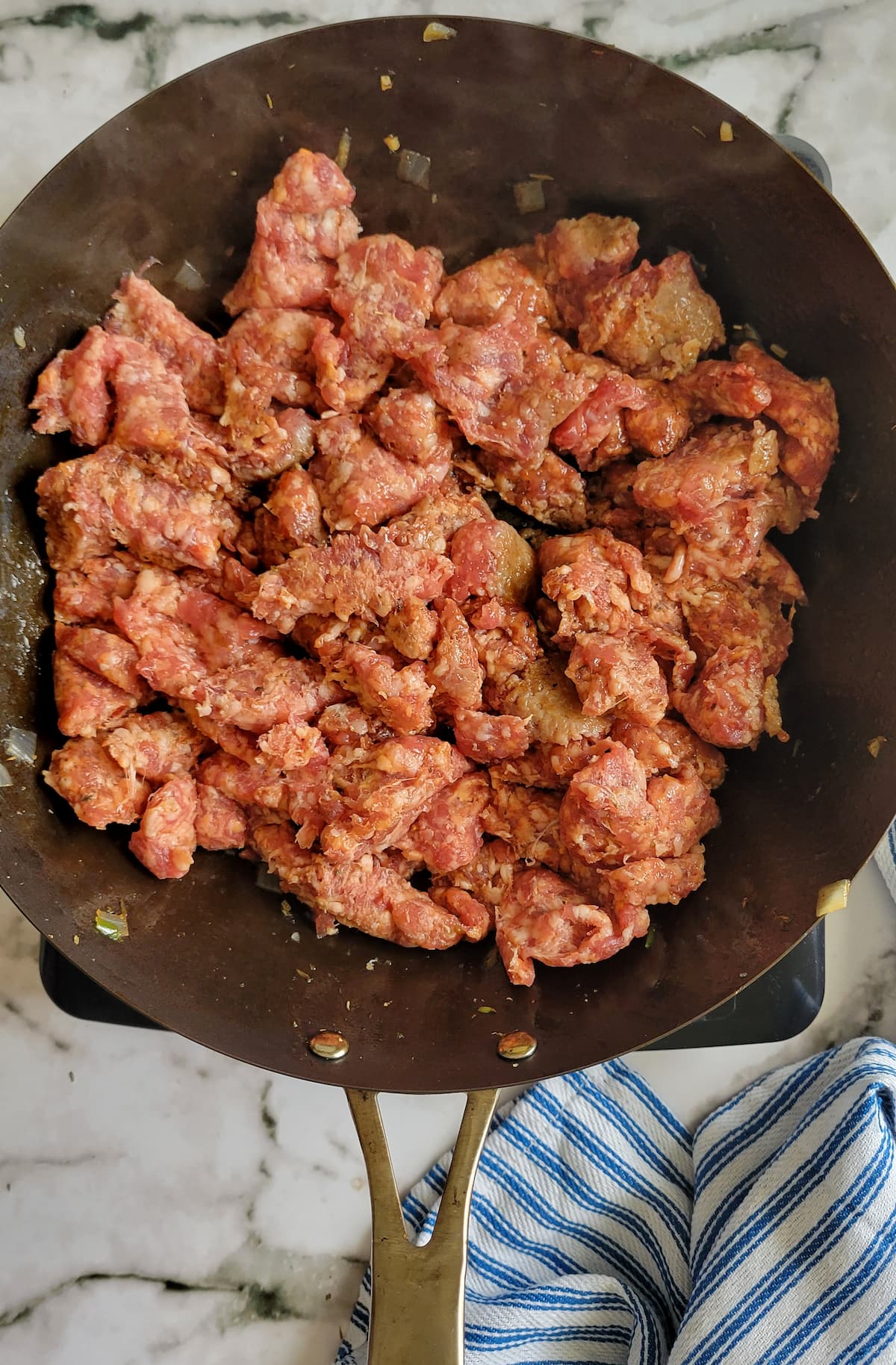 raw ground italian sausage in a skillet