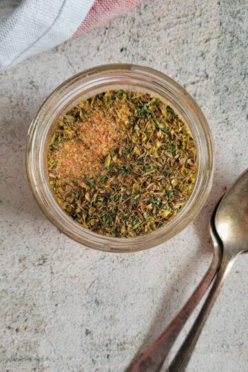 seasoning for chicken in a jar with two spoons