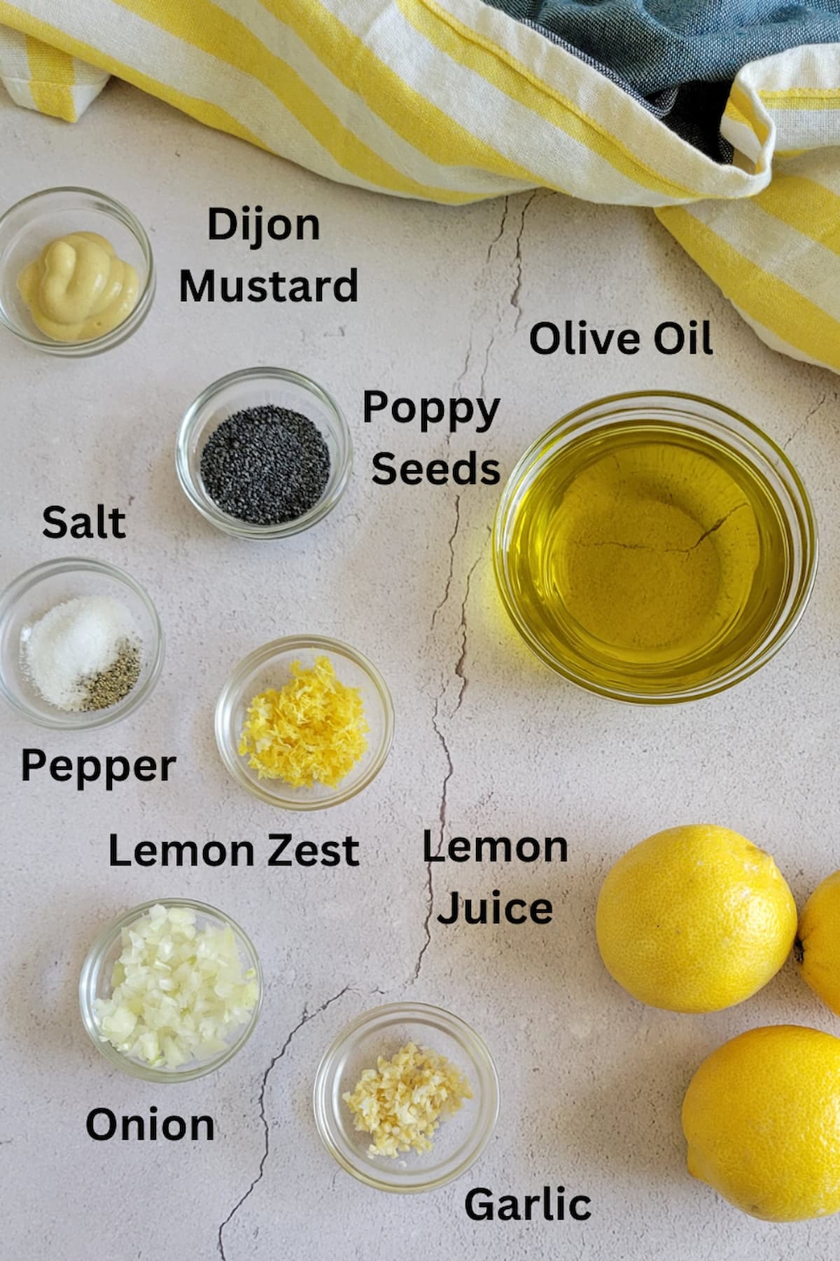ingredient list for recipe for poppy seed dressing - olive oil, lemon juice, lemon zest, onion, garlic, pepper, salt, poppy seeds, dijon mustard