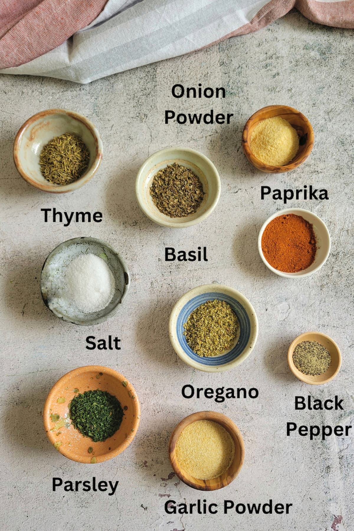 ingredients for seasoning for chicken recipe - thyme, basil, parsley, oregano, garlic powder, onion powder, paprika, black pepper, salt