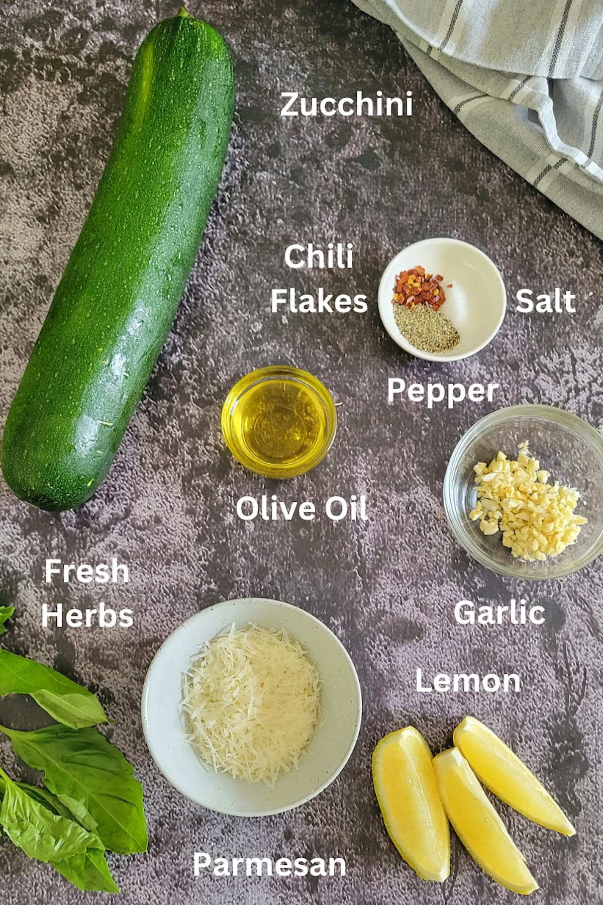 ingredients for sauteed zucchini - zucchini, lemon, fresh herbs, olive oil, parmesan, salt, pepper, chili flakes, garlic