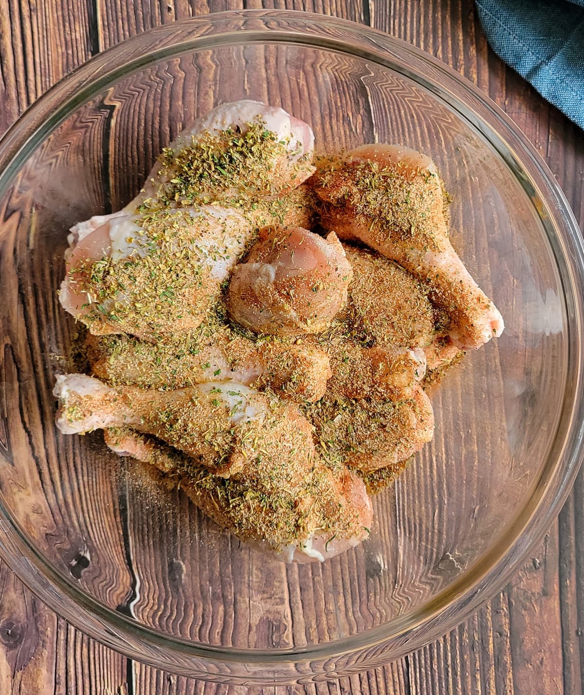 raw drumsticks in a bowl with seasoning