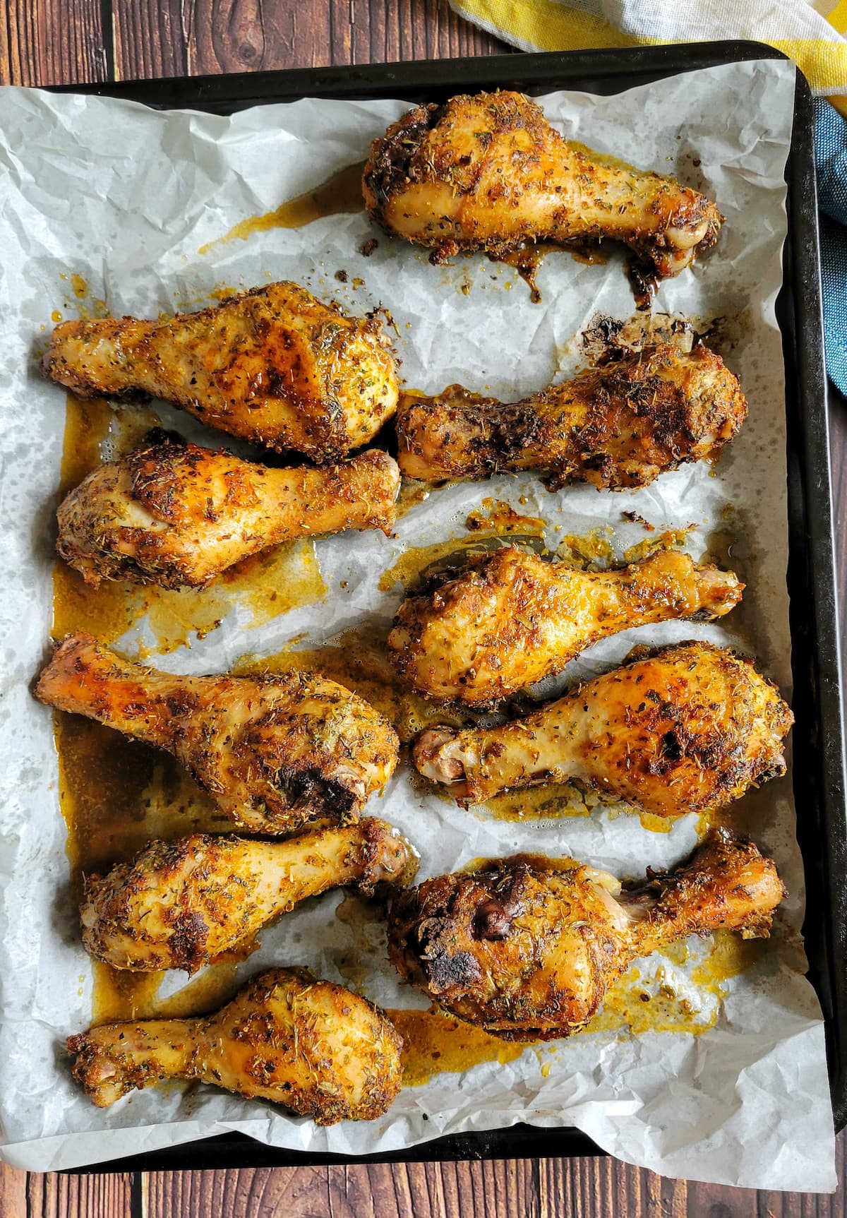 cooked chicken drumsticks on a parchment lined baking tray