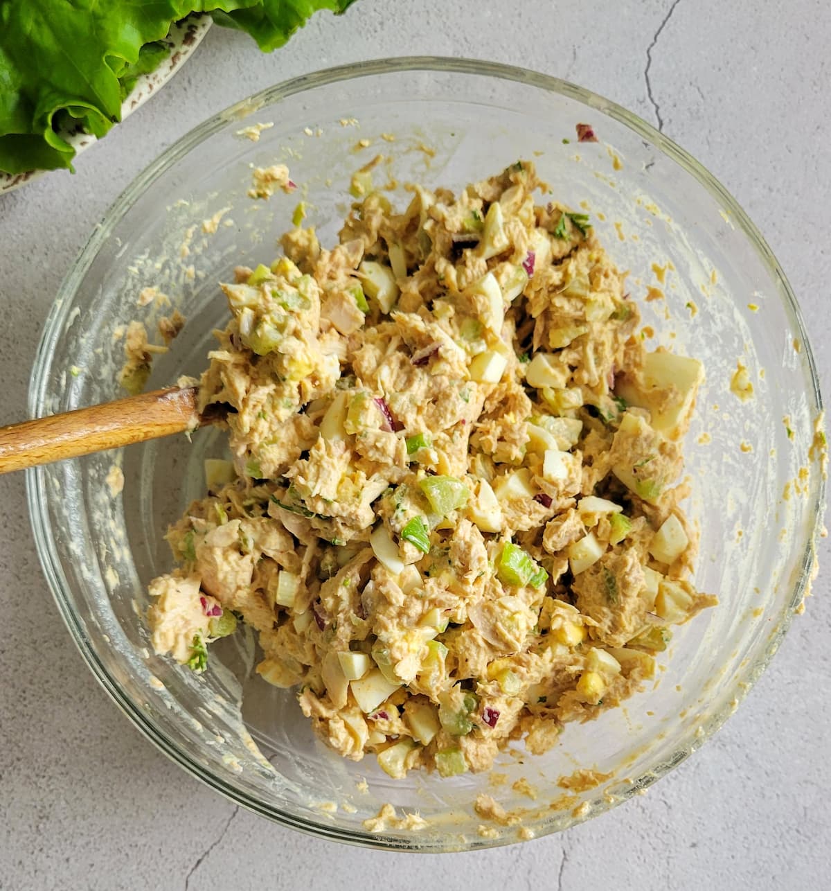 creamy tuna salad with eggs, celery and onions mixed in a bowl with a creamy sauce