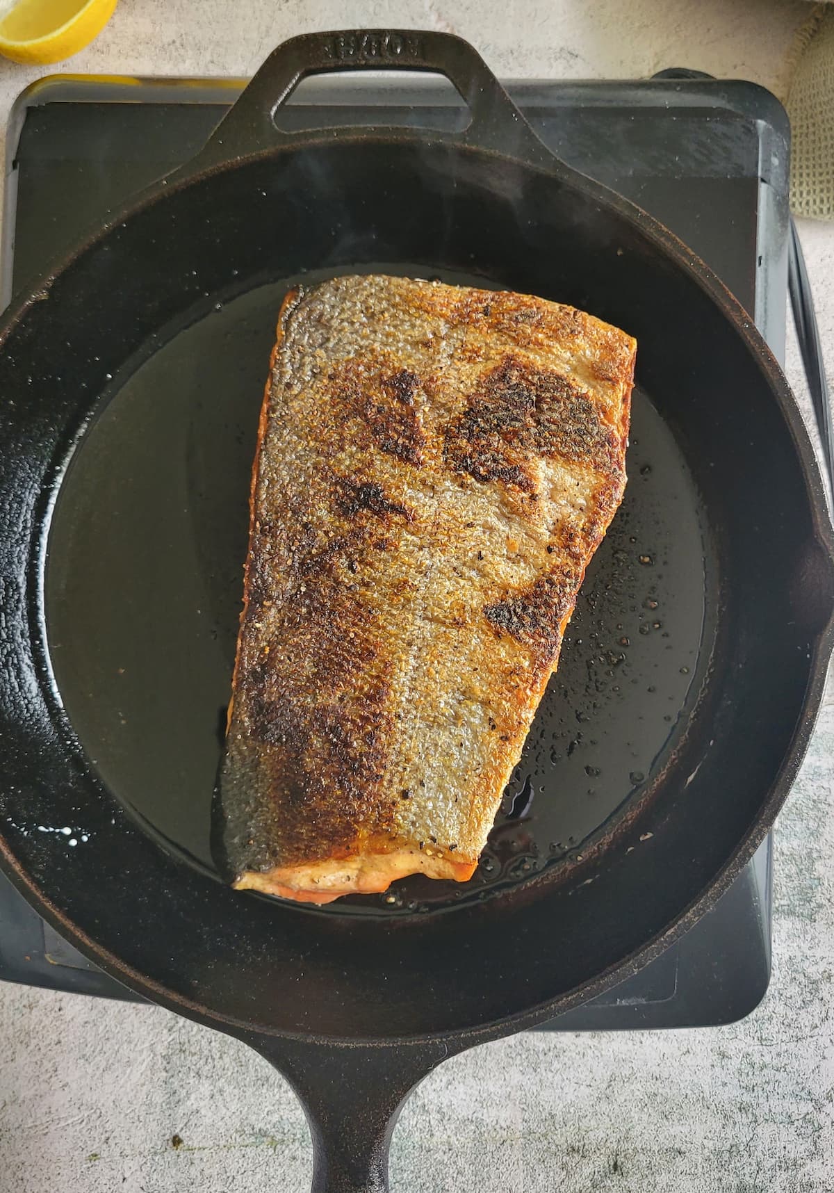salmon, skin facing up, in a cast iron skillet