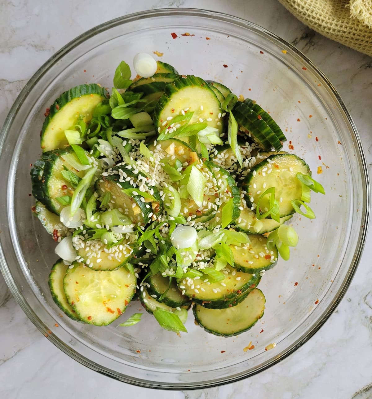 bowl of spicy cucumber with sliced scallions and sesame seeds