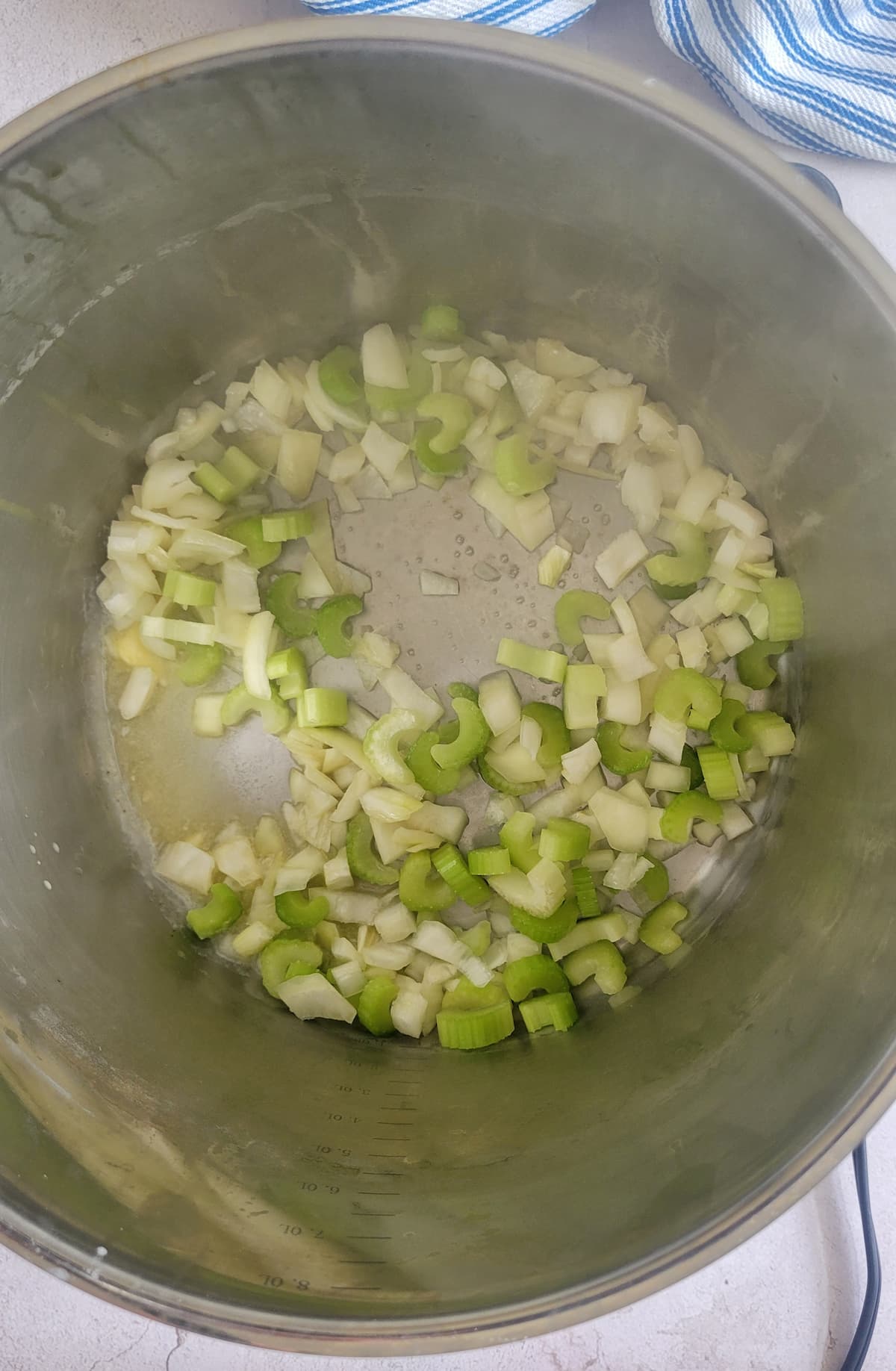 diced onions and celery cooking in a pot with butter