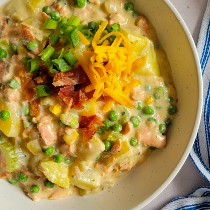 bowl of salmon chowder with potatoes, bacon, green onions and cheddar