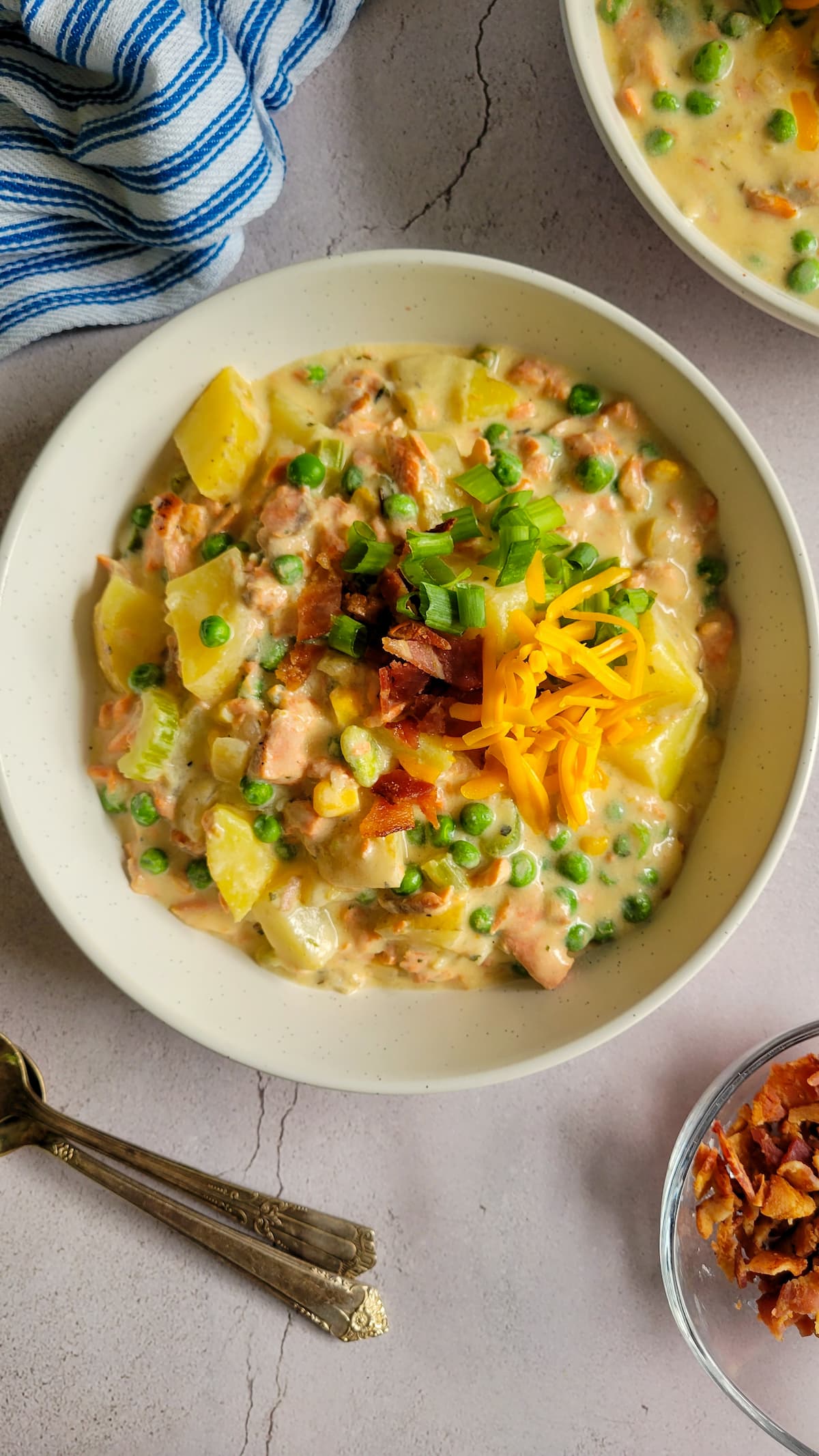 bowl of salmon chowder with potatoes, bacon, green onions and cheddar