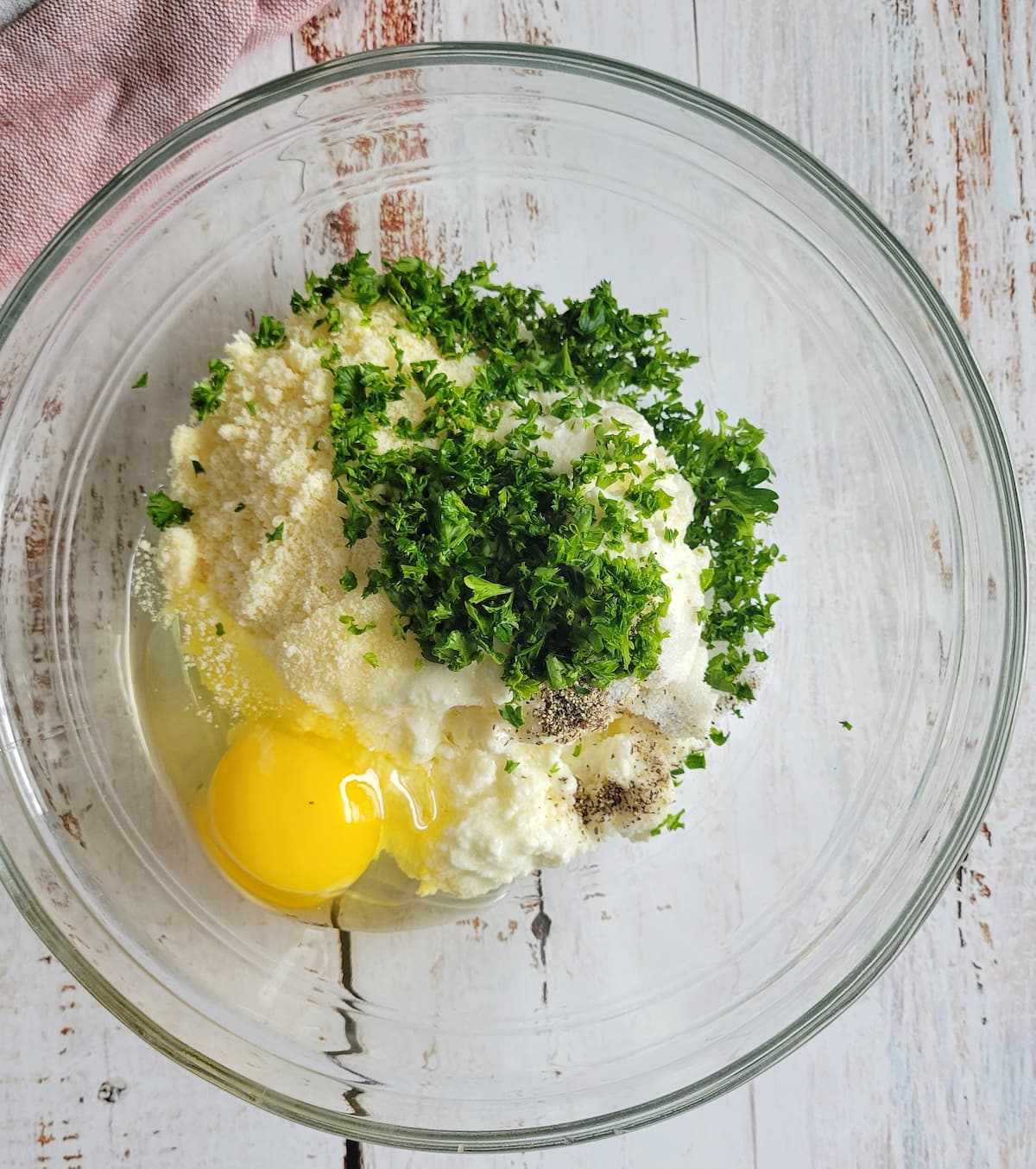 egg, chopped parsley, parmesan, ricotta, salt and pepper unmixed in a bowl