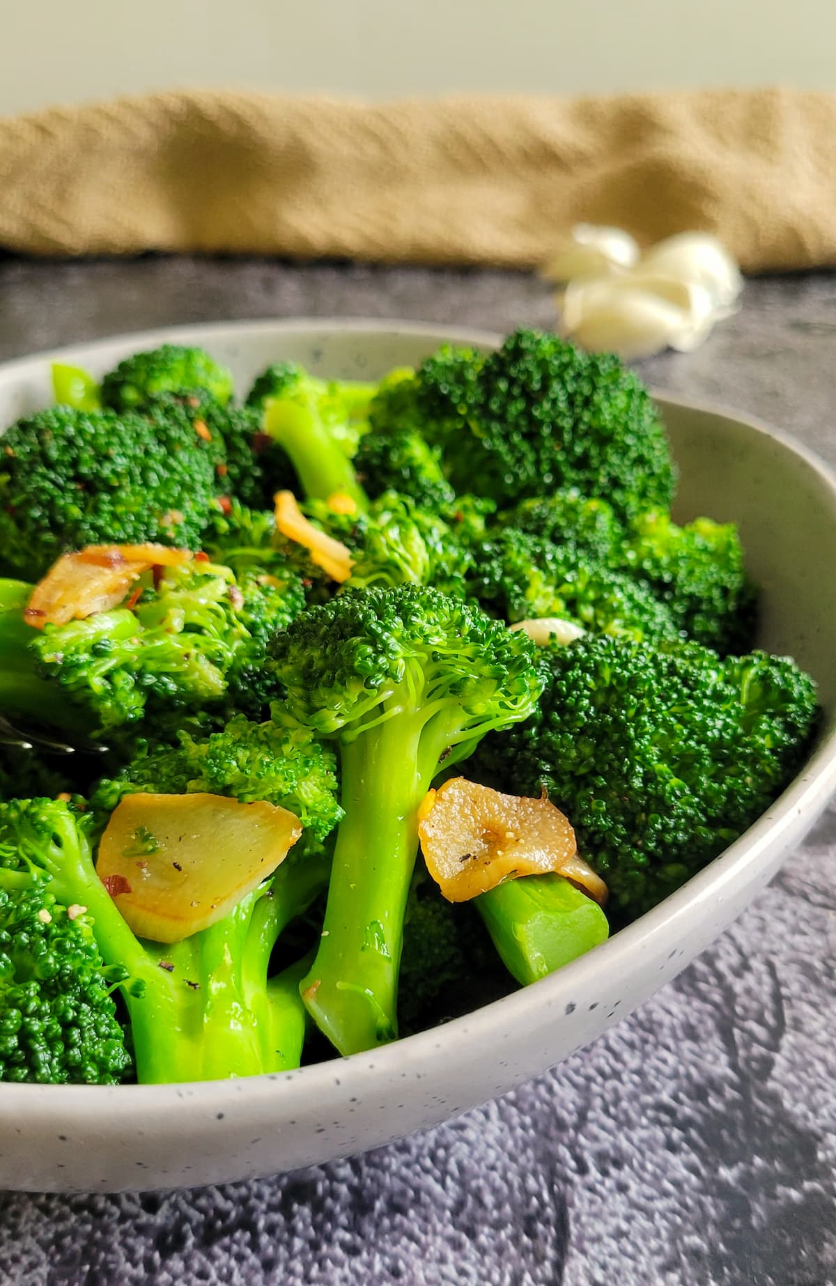 sliced crispy garlic and cooked broccoli in a bowl
