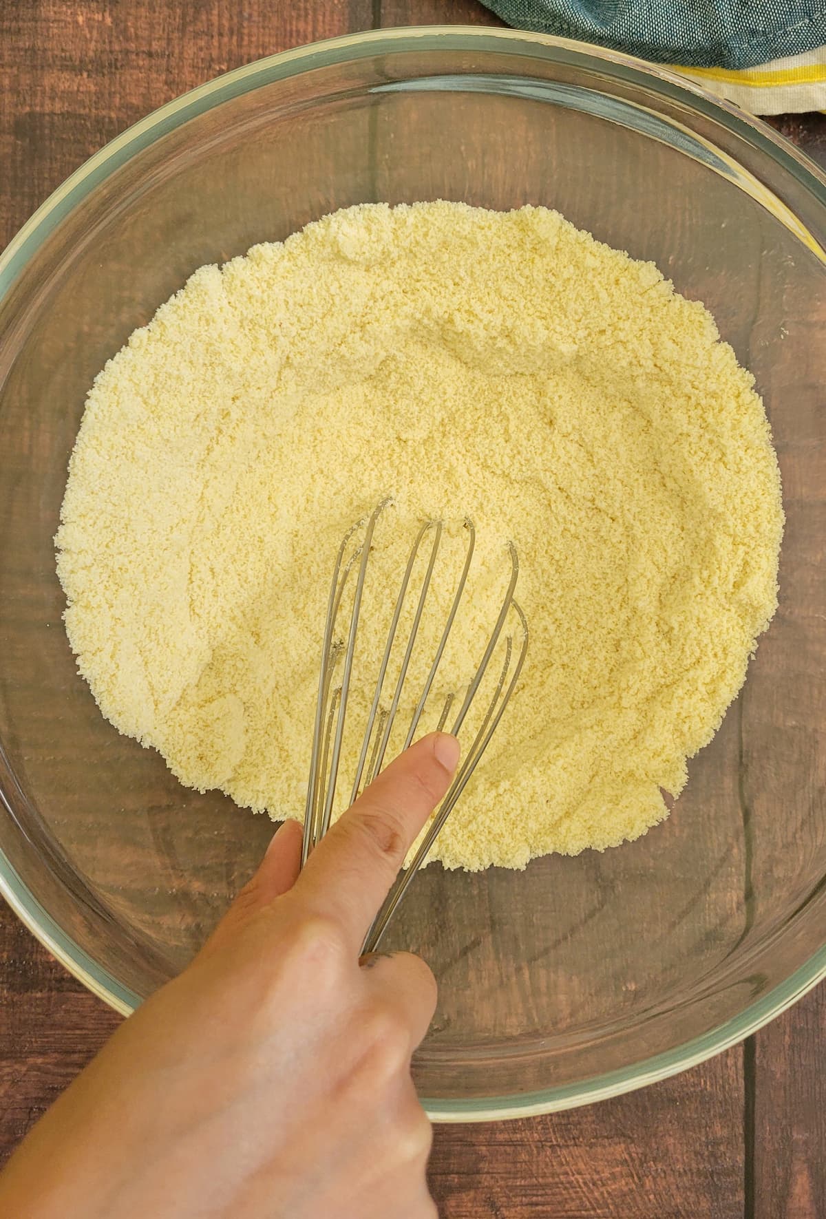 hand whisking together dry ingredients in a bowl
