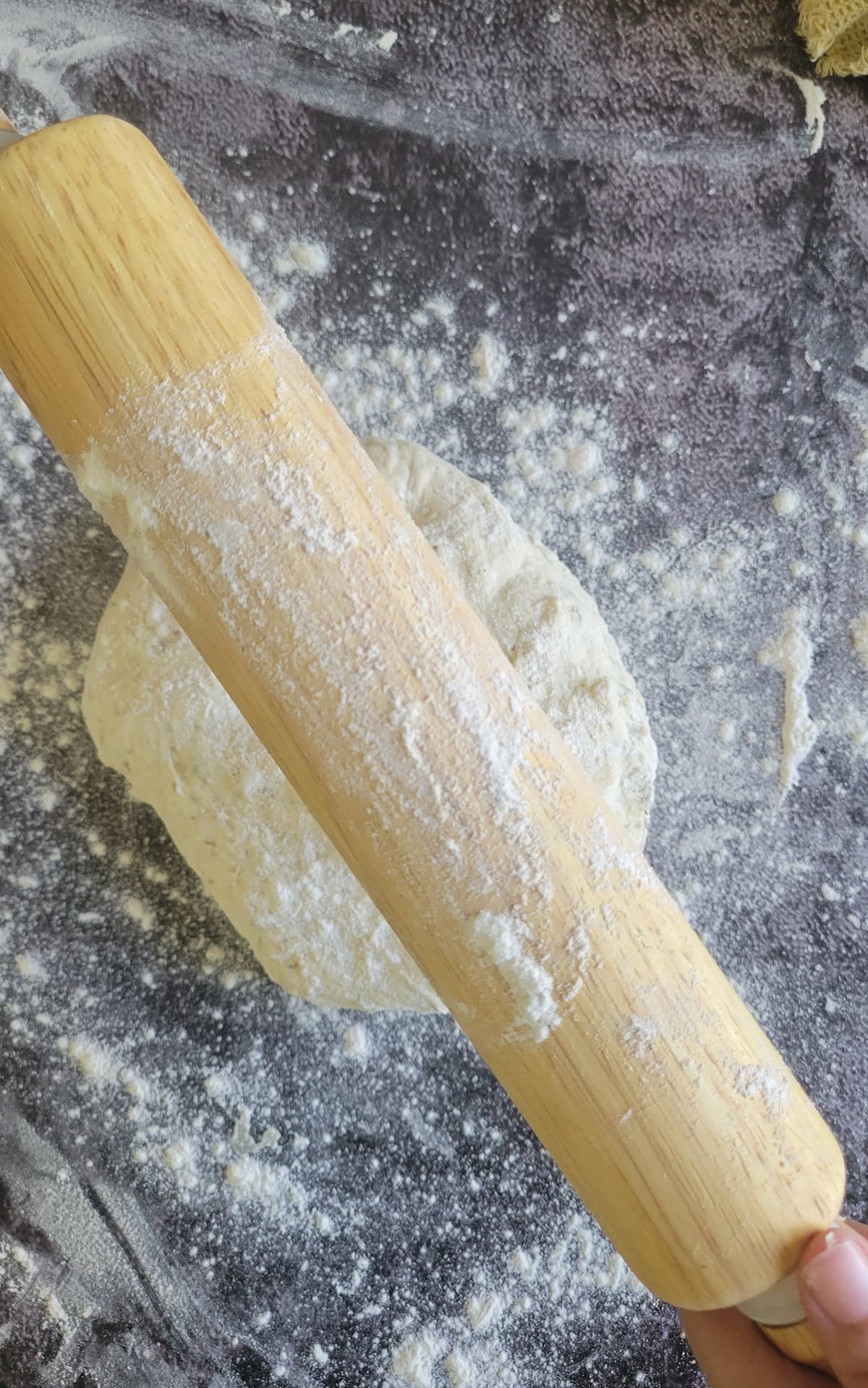 floured rolling pin over a ball of dough on a floured surface