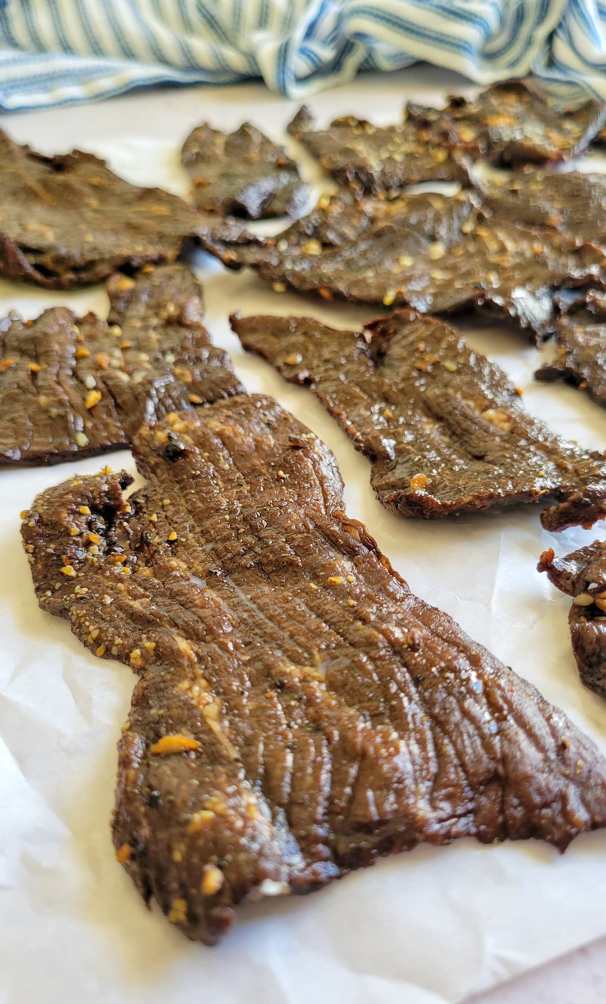 slices of seasoned beef jerky on a piece of parchment paper
