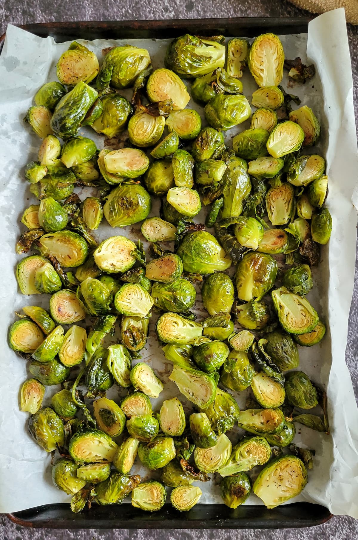 roasted brussels sprouts on a parchment lined baking sheet
