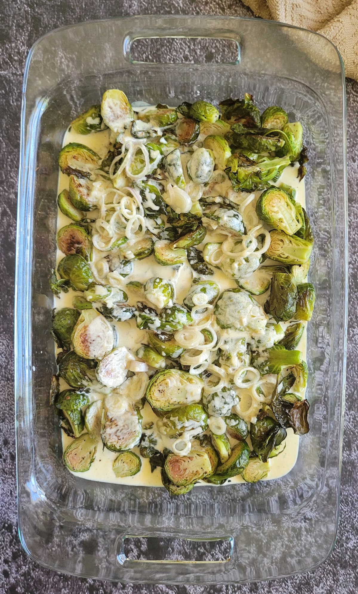 brussels sprouts and shallots in a cream sauce in a baking dish