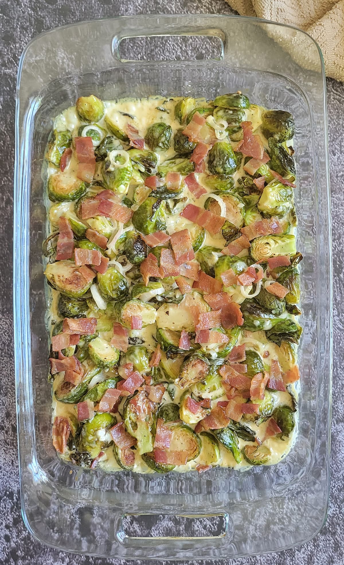 brussels sprouts, bacon and shallots in a creamy sauce in a baking dish