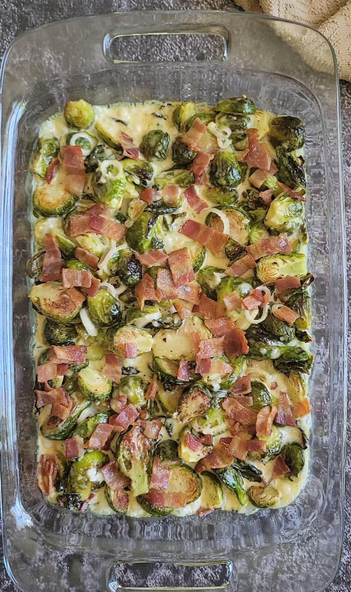 brussels sprouts, bacon and cream sauce in a glass baking dish